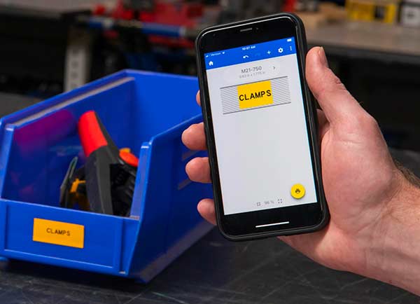 Címketerv az Express Labels Mobile képernyőjén, a ténylegesen kinyomtatott címke mellett. Mindkettő élénksárga, a „CLAMPS” (SZORÍTÓK) felirattal.