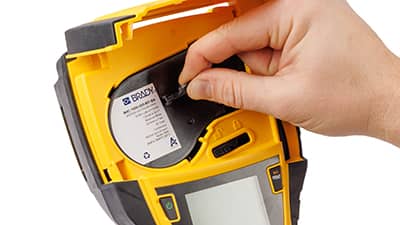 Címkeanyag-tekercs betöltése egy M710 nyomtatóba.