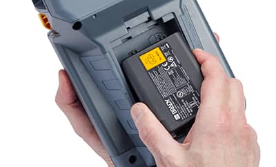 Egy Brady M510 nyomtatóba nagy kapacitású akkumulátort behelyező személy